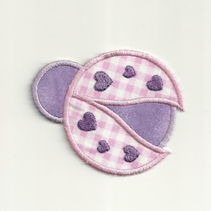 May include: A pink and purple ladybug applique with a white checkered pattern and purple hearts.