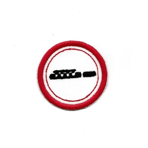 Puede incluir: Parche bordado circular con centro blanco, borde rojo y gráfico negro. El gráfico es una representación estilizada de un cigarrillo con una línea que lo cruza, indicando un símbolo de prohibido fumar. El parche está diseñado para coser o planchar.