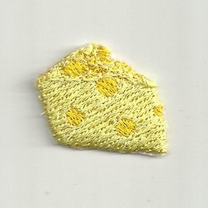 May include: Embroidered patch in the shape of a cheese wedge. The patch is yellow with darker yellow circular accents. The edges are also embroidered in yellow. The patch is on a white background.