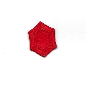 Puede incluir: Parche de fieltro rojo en forma de estrella de seis puntas con una estrella de seis puntas más pequeña en el interior.