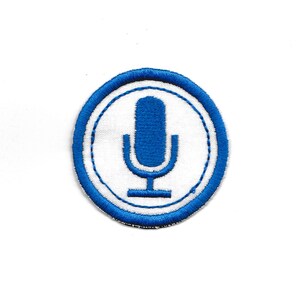 Puede incluir: Parche bordado azul y blanco con un icono de micrófono en el centro.