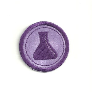 May include: Purple embroidered patch with a round shape and a purple beaker in the center.