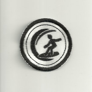 Könnte beinhalten: Ein runder, gestickter Aufnäher mit einem schwarzen Surfer auf einer weißen Welle. Das Design ist von einem weißen Kreis und einem schwarzen Rand umgeben. Geeignet für Kleidung oder Accessoires.