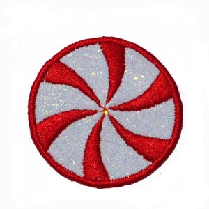 Puede incluir: Un diseño de remolino de caramelo de menta rojo y blanco con purpurina. El diseño es circular y tiene un fondo blanco con remolinos rojos.