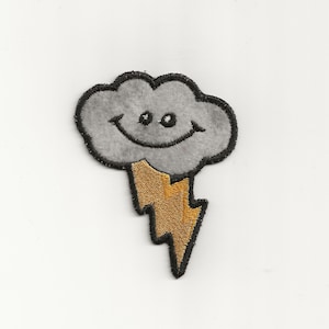 Puede incluir: Una nube gris sonriente con un rayo amarillo debajo. La nube y el rayo están bordados.