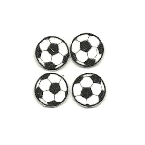 May include: Four black and white embroidered iron-on patches of soccer balls.