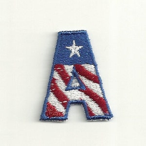 May include: An embroidered iron-on patch in the shape of the letter A. The letter is filled with an American flag design with red and white stripes and a blue field with a white star.