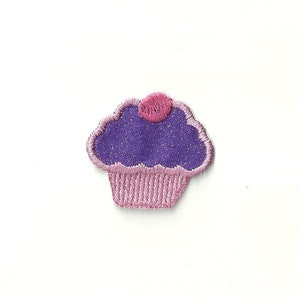 May include: Purple cupcake with pink frosting and a pink sprinkle on top. The cupcake is embroidered with glitter.