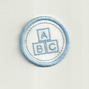 May include: A blue and white embroidered patch with the letters A, B, and C in blocks, representing building blocks.