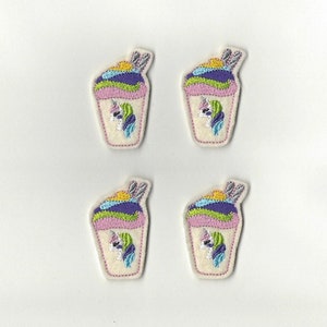 May include: Four embroidered iron-on patches featuring a unicorn ice cream cone with a pink, purple, green, and yellow swirl. The unicorn has a white body, a pink horn, and a blue tail.