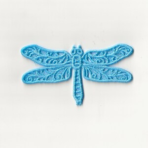 May include: A light blue embroidered dragonfly patch. The dragonfly has detailed wing patterns and a delicate, openwork design. This decorative patch is suitable for clothing, accessories, or craft projects.