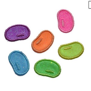 May include: Six colorful jelly bean shaped iron-on patches with glitter. The patches are purple, orange, green, blue, pink and yellow.