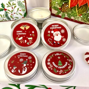 May include: Several small, round, silver tins with red labels displaying festive Christmas designs and the words "MERRY CHRISTMAS." The labels show bells, Santa Claus, snowmen, and Christmas trees. The tins contain white wax.