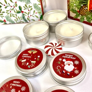 May include: Several small, silver candle tins filled with white wax and wicks. The lids are adorned with red labels displaying "Merry Christmas" and festive illustrations. A peppermint candy and a gift box with holly designs are also present.