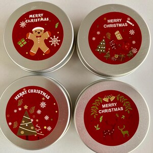 May include: Four small, round, silver tins with red labels. Each tin has "Merry Christmas" text and festive illustrations, including a gingerbread man, Christmas tree, and reindeer, ideal for gifting.