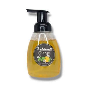 May include: A clear bottle of yellow liquid with a black pump dispenser. The bottle has a black and white label that says "Patchouli Orange" with a small illustration of an orange and leaves.