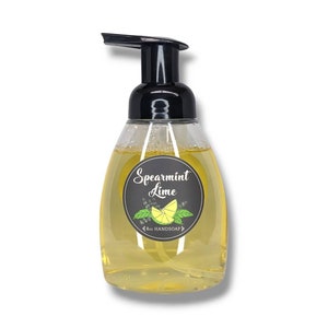 Pode incluir: Uma garrafa de plástico transparente de sabonete líquido para as mãos de 8 oz com aroma de hortelã e limão com um dispensador de bomba preto. O rótulo apresenta um círculo preto com texto branco e uma ilustração de limão.