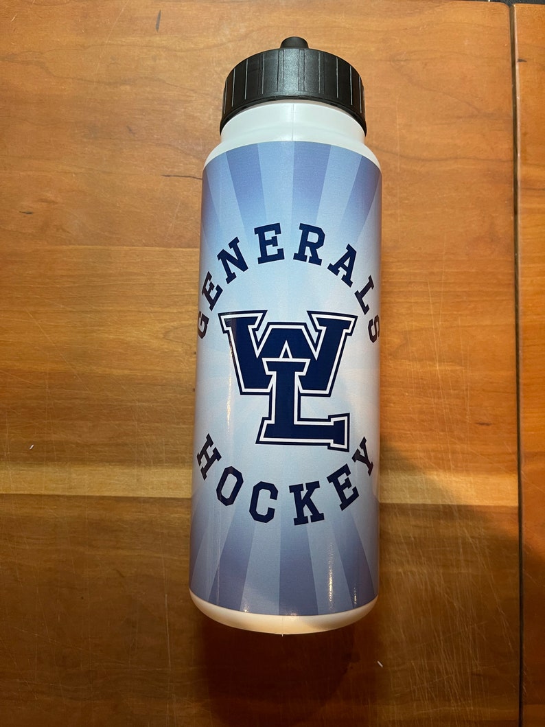 May include: White water bottle with a black cap. The bottle features the text "GENERALS HOCKEY" in navy blue, with a stylized "WL" logo. The background has a light blue radial design.