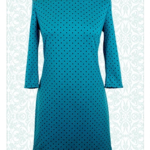 Könnte beinhalten: Ein türkisfarbenes Kleid mit schwarzen Punkten und einem Boot Ausschnitt. Das Kleid hat Dreiviertelärmel.