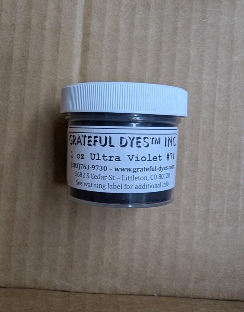 May include: A small jar of Ultra Violet #74 dye from Grateful Dyes Inc. The jar has a white lid and a label with product information. The jar contains 1 oz of dye.
