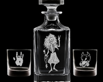 May include: A clear glass decanter set with a square decanter and two matching lowball glasses. The decanter features an etched skeleton design, and the glasses have a handprint and wolf design.