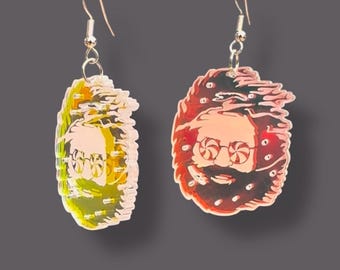 May include: A pair of earrings featuring a psychedelic portrait of a man with a beard and sunglasses. The earrings are made of clear acrylic and have a gold-tone hook.