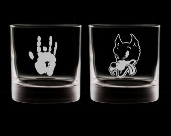 May include: Two clear glass tumblers with etched designs. One tumbler features a white handprint, the other features a white wolf's head.