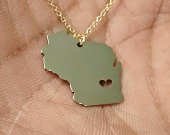 May include: A gold necklace with a pendant shaped like the state of Wisconsin. The pendant has a small heart cut out of it.