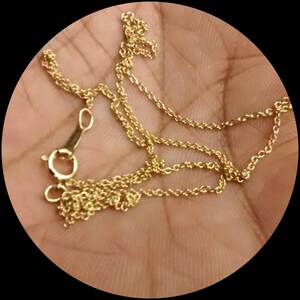 May include: A gold chain necklace with a lobster clasp closure.