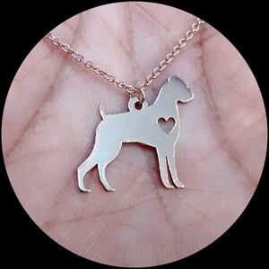 May include: A rose gold necklace with a cutout silhouette of a boxer dog with a heart on its chest.