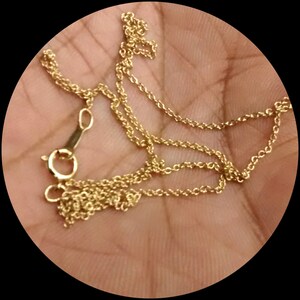 May include: A gold chain necklace with a lobster clasp closure.