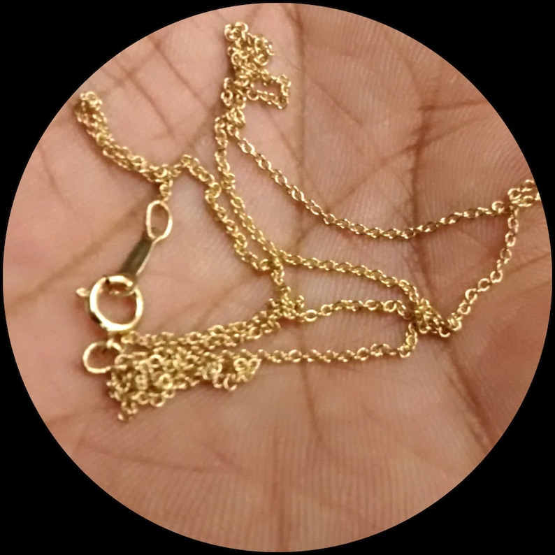May include: A gold chain necklace with a lobster clasp closure.