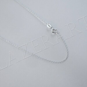 May include: A silver chain necklace with a lobster clasp closure. The chain is on a white background with the word "LAZERART" printed on it.