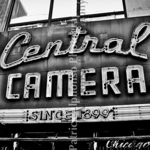 Könnte beinhalten: Schwarzweißfoto eines Vintage-Neonschilds für Central Camera, ein Geschäft in Chicago, Illinois. Das Schild lautet "Central Camera" und "Seit 1899".