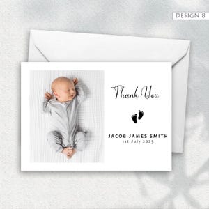 May include: A baby thank you card with a photo of a newborn in a gray onesie. The card includes the text "Thank You", baby footprints, and the name "JACOB JAMES SMITH" with the date "1st July 2025". The card is white with a white envelope.