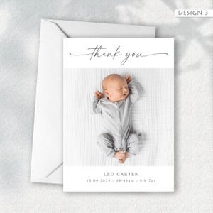 May include: A white card with a baby photo and the words "thank you" in elegant script. The baby is wearing a gray onesie. The card includes the baby's name, birthdate, time, and weight. A white envelope is included.