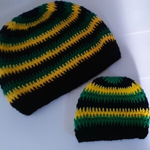 Puede incluir: Dos gorros de punto de ganchillo en rayas negras, verdes y amarillas. El gorro m&aacute;s grande es ligeramente m&aacute;s alto que el m&aacute;s peque&ntilde;o.