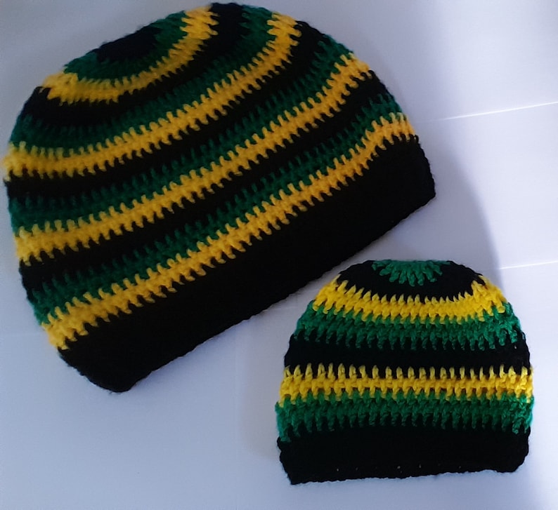 Puede incluir: Dos gorros de punto de ganchillo en rayas negras, verdes y amarillas. El gorro m&aacute;s grande es ligeramente m&aacute;s alto que el m&aacute;s peque&ntilde;o.