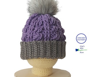 Può includere: Cappello a uncinetto viola e grigio con un pon pon in pelliccia sintetica grigia. Il cappello è su una forma di cappello a uncinetto. Il testo "CROCHET PATTERN Gigi's Blue Rose" è su un cerchio blu con un contorno bianco.