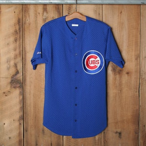 May include: A blue baseball jersey with a white collar and a red, white, and blue Chicago Cubs logo on the front.