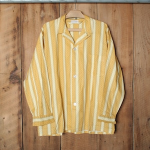 Puede incluir: Una camisa de manga larga a rayas amarillas y blancas con cierre de botones y cuello.