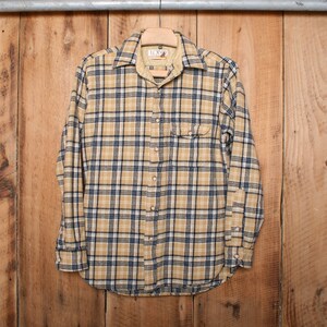 May include: A yellow and black plaid flannel shirt with long sleeves and a button-up front.