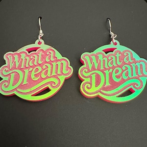May include: A pair of iridescent green and pink earrings with the words "What a Dream" on each earring.