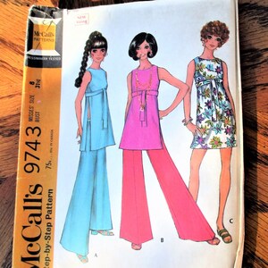 May include: Vintage McCall's 9743 sewing pattern featuring illustrations of women's dresses and pantsuits. The pattern includes a blue pantsuit, a pink top and pants, and a floral print dress. The pattern is for Misses size 8, with a 31-inch bust.