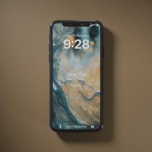 Puede incluir: Un iPhone negro con un fondo abstracto azul y amarillo. La hora es 9:28 y la fecha es viernes, 18 de noviembre. El teléfono está en modo No molestar y no tiene ninguna alarma configurada. El texto "Sleep Well" se muestra en la pantalla. El teléfono está sobre una superficie marrón.