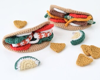 May include: Crocheted food set featuring two tacos with various fillings, including red, white, and green elements. The set also includes crocheted tortilla chips and a slice of avocado. The tacos are made with tan yarn.