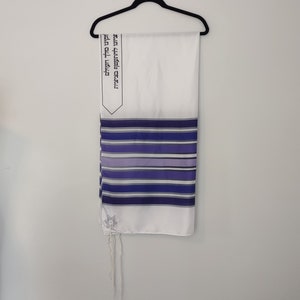 Op de afbeelding: Wit gebedssjaal met blauwe en paarse strepen en een Davidster. De Hebreeuwse tekst op de sjaal luidt: "Gezegend zijt Gij, Heer onze God, Koning van het universum, die ons geheiligd heeft met Zijn geboden en ons bevolen heeft om ons in tsitsit te hullen."