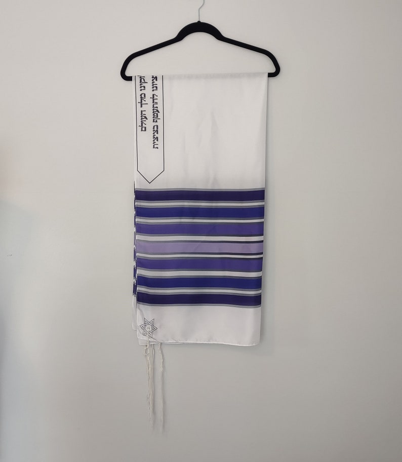 Op de afbeelding: Wit gebedssjaal met blauwe en paarse strepen en een Davidster. De Hebreeuwse tekst op de sjaal luidt: "Gezegend zijt Gij, Heer onze God, Koning van het universum, die ons geheiligd heeft met Zijn geboden en ons bevolen heeft om ons in tsitsit te hullen."
