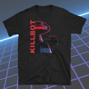 May include: Black t-shirt featuring a red and blue graphic of a robot with the word "KILLBOT" in red vertical text. The design has a retro, futuristic aesthetic.