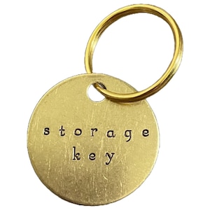 May include: A gold-colored metal keychain with a round tag that says "storage key".